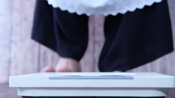 Woman's Feet on Weight Scale Close Up.