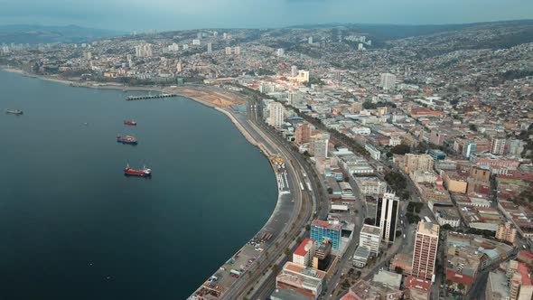 Aerial dolly in of Valparaiso hillside city buildings and Sea Port with container cargo ships sailin