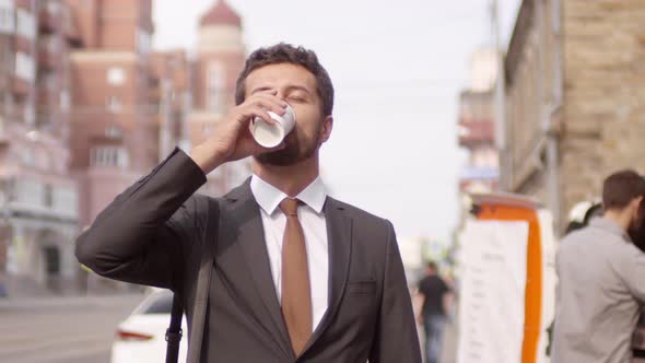 Handsome Businessman Drinking Takeaway Coffee near Street Van