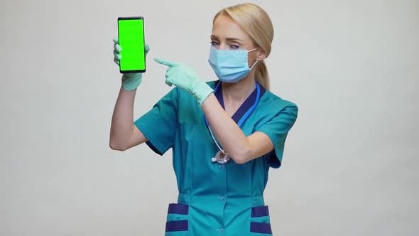 Medical Doctor Nurse Woman Wearing Protective Mask and Gloves - Showing Presenting Mobile Phone