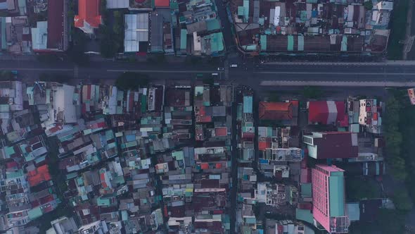 early morning top down drone high view of street and rooftops in a busy and densely populated area f