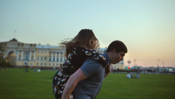 Happy Couple Playing in the Summer Field. Man-horse Riding Joke