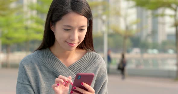 Woman use of mobile phone in city park