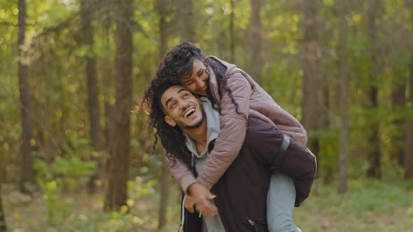 Attractive Playful Girl Fooling Around Playing with Hair Hugging Guy By Shoulders Boyfriend Holding