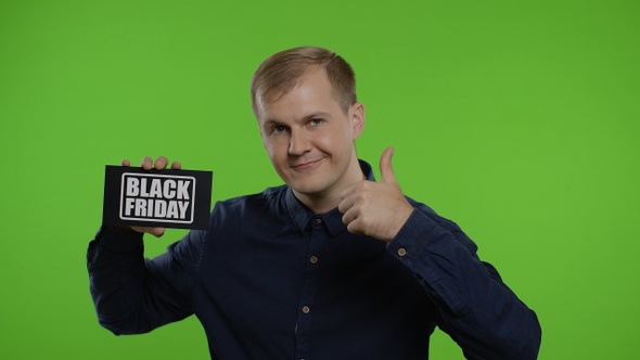 Happy Man Holding Black Friday Inscription, Showing Thumb Up. Guy Rejoicing with Good Sale Discounts