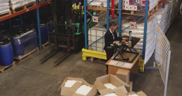 Female warehouse manager working standing at a desk 4k