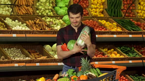 Man Puts Different Vegetables Into the Shopping Cart