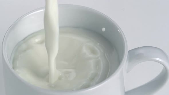 Close-up milk being poured into a white mug, Slow Motion