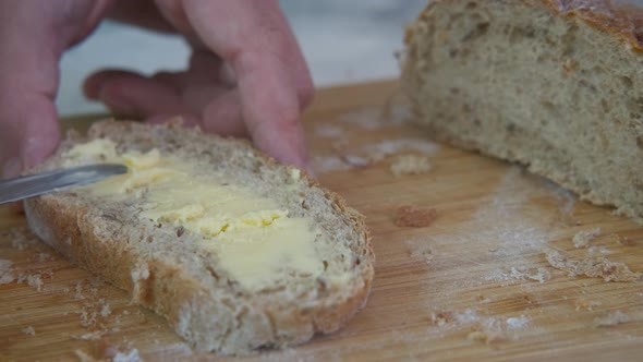 Spread butter on bread slice. 