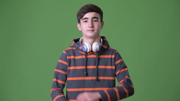 Young Handsome Iranian Teenage Boy Against Green Background