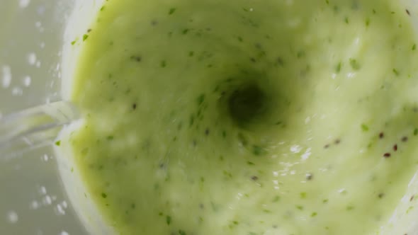 Close Up Blending Fruits Like Banana Pineapple and Spinach Viewed Through a Shaking Lid