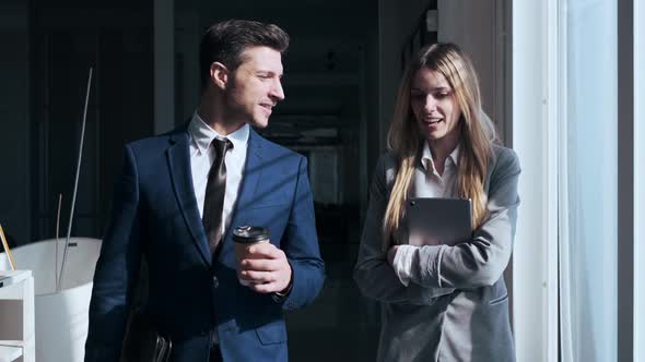 Businessman and woman leaving coffee shop, talking