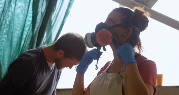 Woman wearing gas mask in workshop 4k