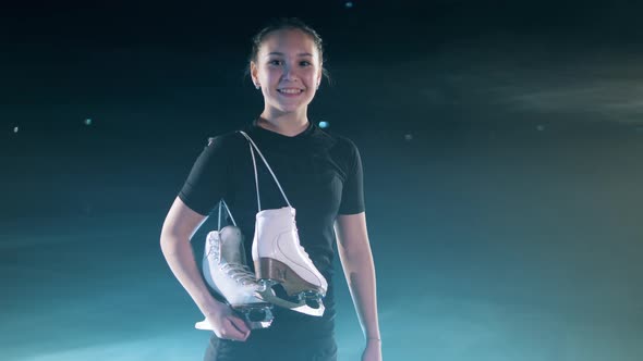 Young Girl is Smiling with the Skates Over Her Shoulder