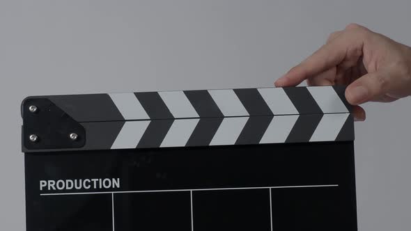 Movie slate or clapperboard hitting. Close up hand holding empty film slate and clapping it. Open