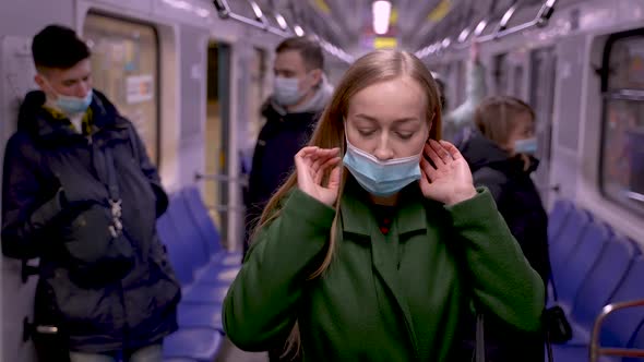 Conscious Woman Putting on Face Mask in Metro Car