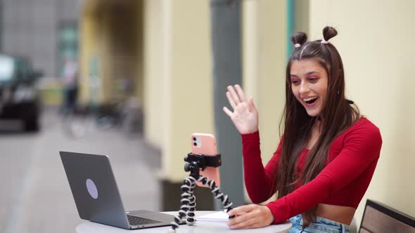 Freelance Woman in a Summer Cafe Communicating Via Video Link