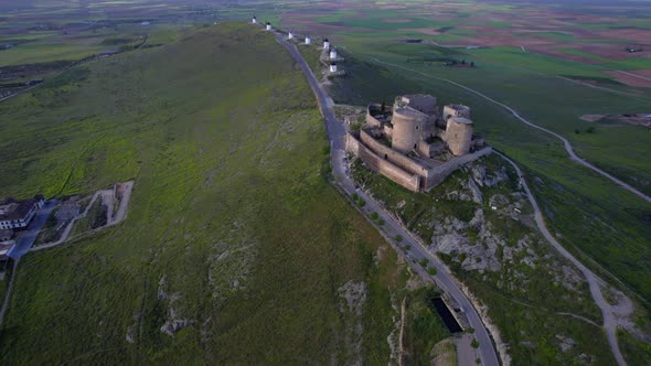 Aerial top view of medieval castle and windmills in line on top of hill. Consuegra, Spain
