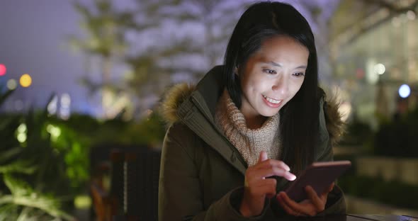 Woman using cellphone at night