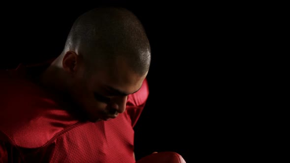 American football player holding a football with both his hands 4k