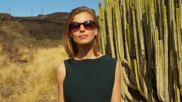 Stunning Female Model Posing with Cactus and Other Plants in Background