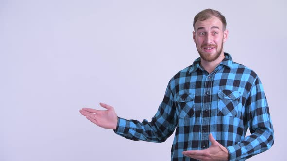 Happy Bearded Hipster Man Showing Something and Looking Surprised