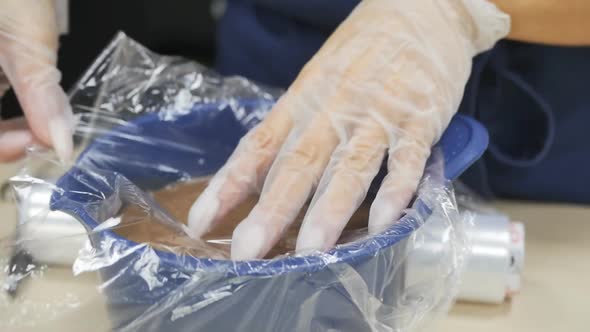 Pastry Chef Covers Melted Chocolate in a Bowl with Cling Film in Contact