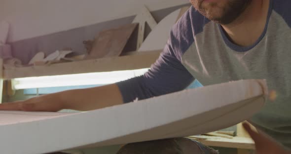 Male surfboard maker in his workshop