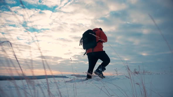 Backpacker Walking on Snow Mountain in Winter. Man with Backpack Trekking in Mountains
