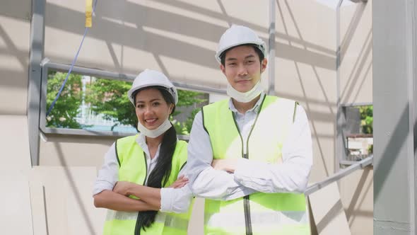 Asian workers people removes protective face mask onsite of architecture due to COVID 19.