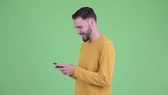 Profile View of Young Handsome Bearded Man with Phone Being Taken Away