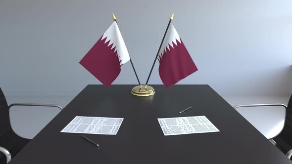Flags of Qatar and Papers on the Table alt