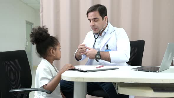 A doctor at an international hospital Trying to check up of a mischievous child in the hospital's OP