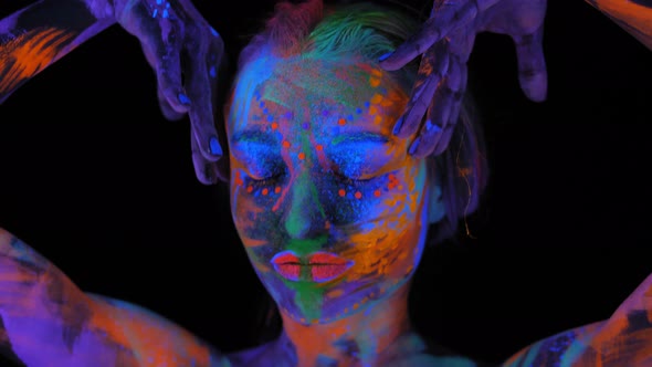 A Magical Space Girl with UV Drawings on Her Face and Body in the Dark