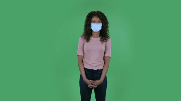 Portrait of Beautiful African American Young Woman in Medical Mask Is Looking Straight and Waves His