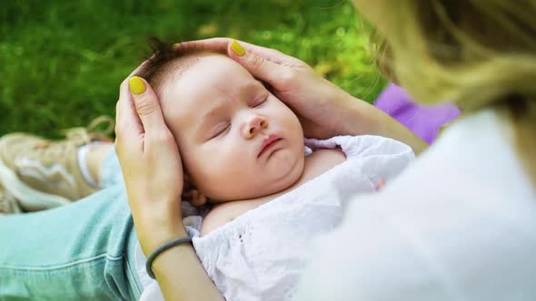 Caring mother spending time with sleeping child outside