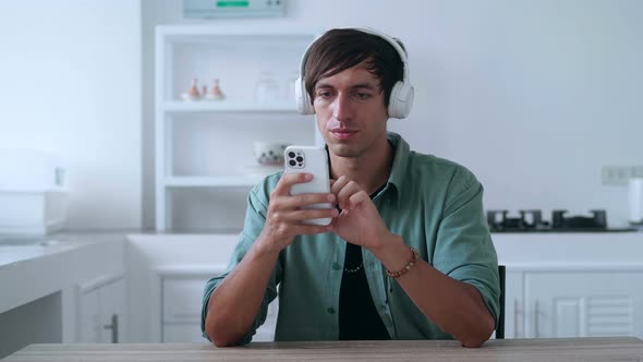 Happy Man in Headphones Looking at Smartphone Celebrate Success Mobile Win Online Bet