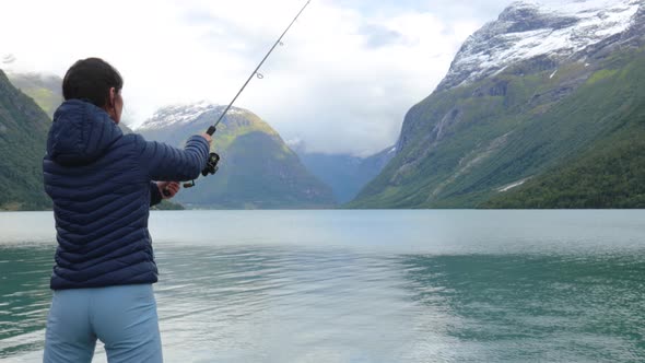 Woman Fishing on Fishing Rod Spinning in Norway