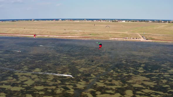 People go kitesurfing on the sea. The wind carries the athlete along the sea waves.