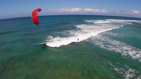 Aerial view of a man kitesurfing in Hawaii.