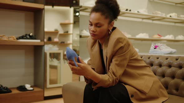 AfricanAmerican Woman While Choosing Fashionable Highheeled Shoes