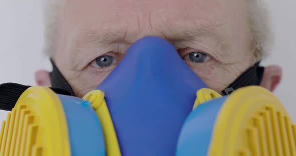 Macro Look Into Camera of Blueeyed Senior Man Wore in Universal Respirator