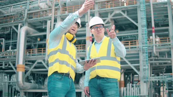 Workers in Safety Wear are Talking on the Oil Refinery Premises