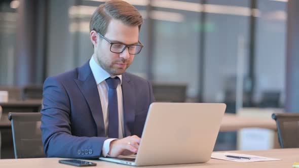 Businessman Working on Laptop in Office