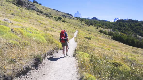 Young woman wearing backpack walking on a trail in Patagonia, Argentina. Trek around Fitz Roy in Los