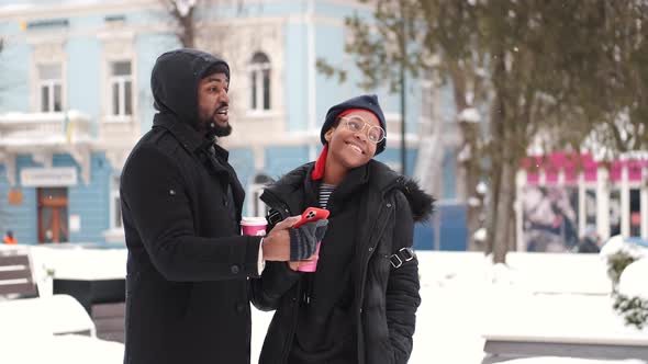 Couple Drinking Coffee and Exploring City on Winter Day