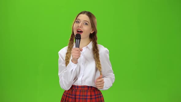 Girl Sings Into the Microphone. Green Screen