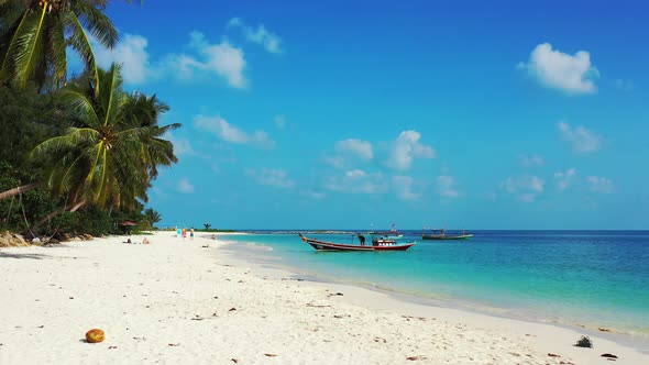 Paradise vacation exotic beach with white sand, palm trees with beautiful leaves hanging over turquo