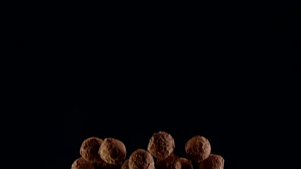 Closeup Dark Chocolate Truffles Colliding with Luster Cocoa Powder in Air