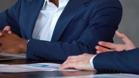 Young people in a suits shaking hands in workplace